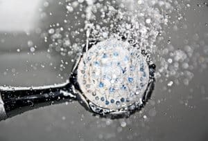 Cette méthode secrète pour vieillir en beauté : « 2 douches par semaine à partir de 65 ans » révèlent les experts Close-up of a shower head releasing water droplets, creating a crisp and refreshing bathroom scene.