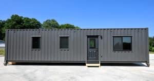 Cette maison conteneur révolutionnaire abrite confortablement une famille et leur voiture, défiant les limites de l’espace!