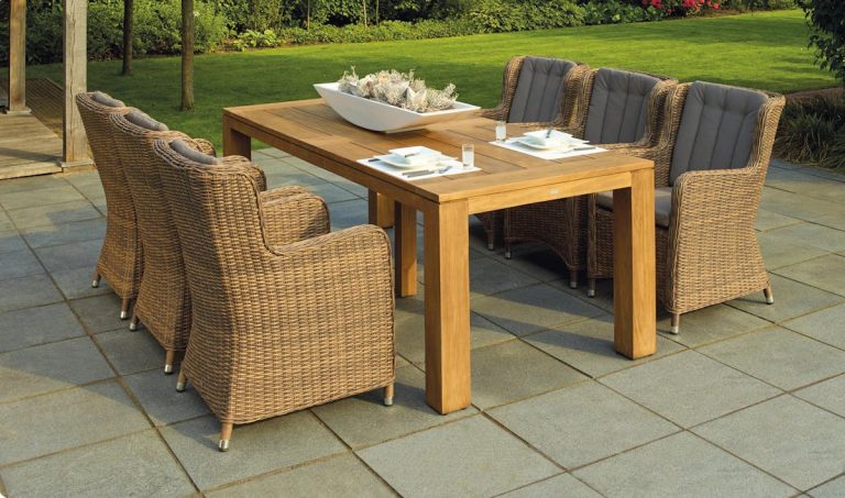 Guide complet pour bien choisir son salon de jardin adapté à vos besoins A serene outdoor patio set up with rattan chairs and a wooden table, perfect for relaxation.