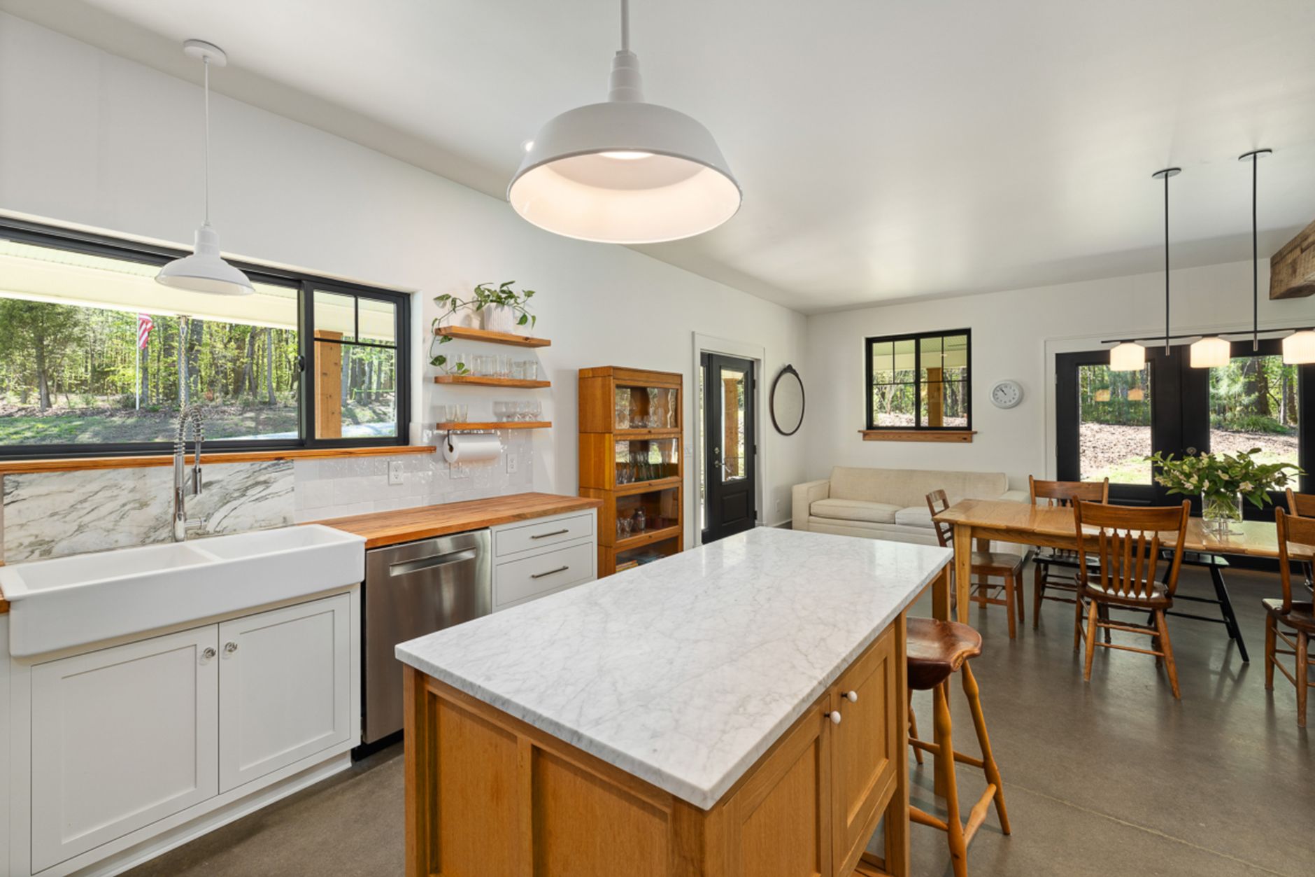 Cuisine moderne et lumineuse avec des comptoirs en marbre, des accents de bois et des luminaires suspendus.