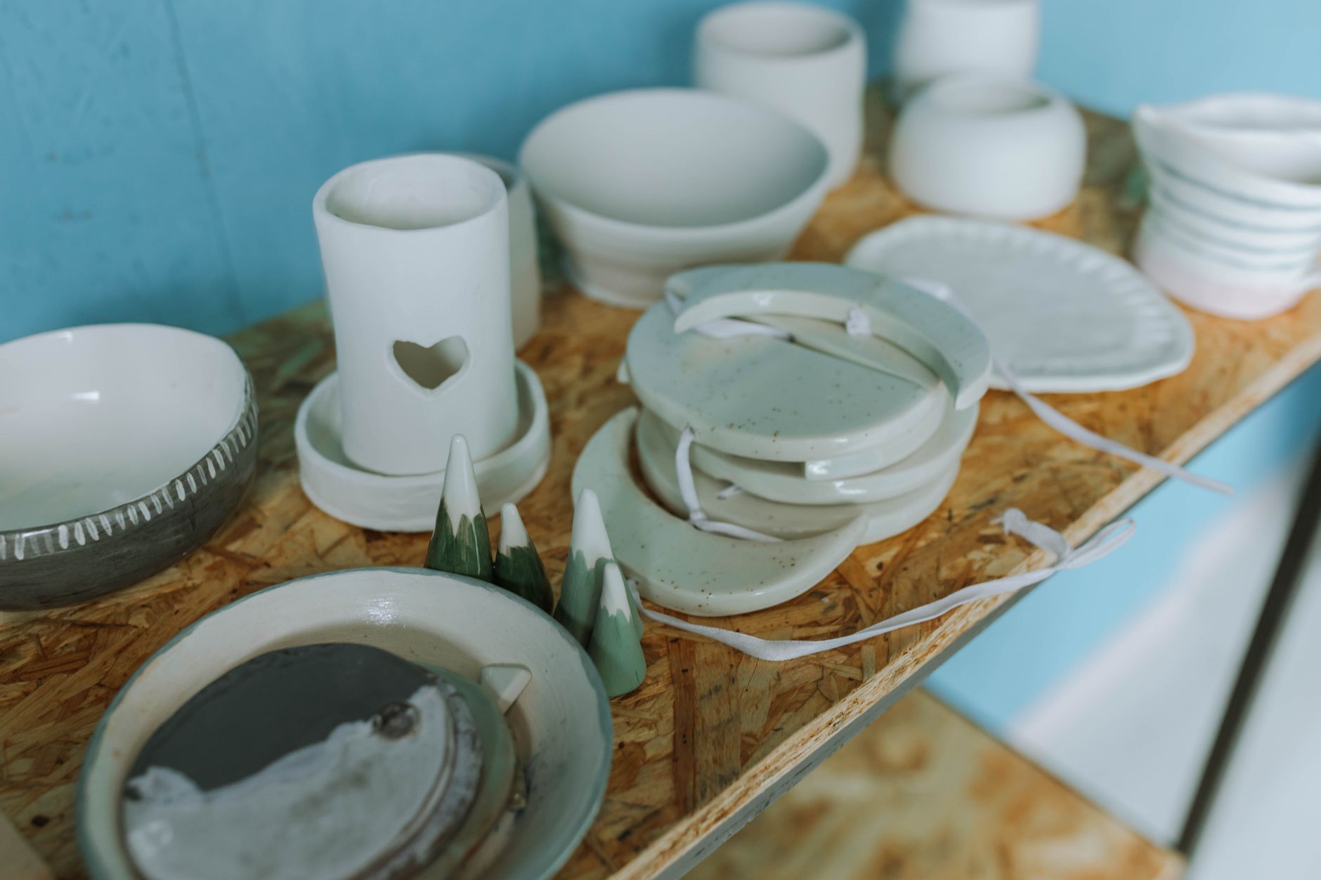 Poteries artisanales sur une étagère en bois à l'aspect rustique, parfaites pour la décoration intérieure.