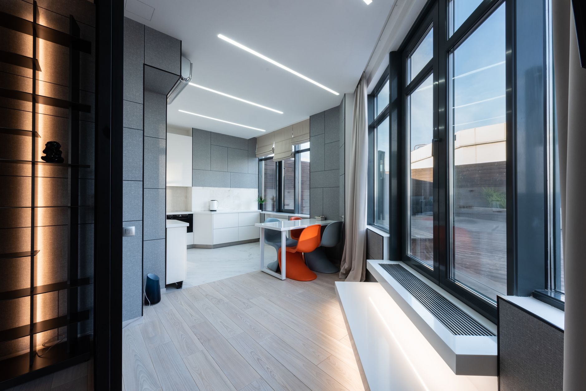 Intérieur de maison lumineuse vide avec fenêtres et rideaux près d'une table avec des chaises et des comptoirs dans la zone de cuisine.